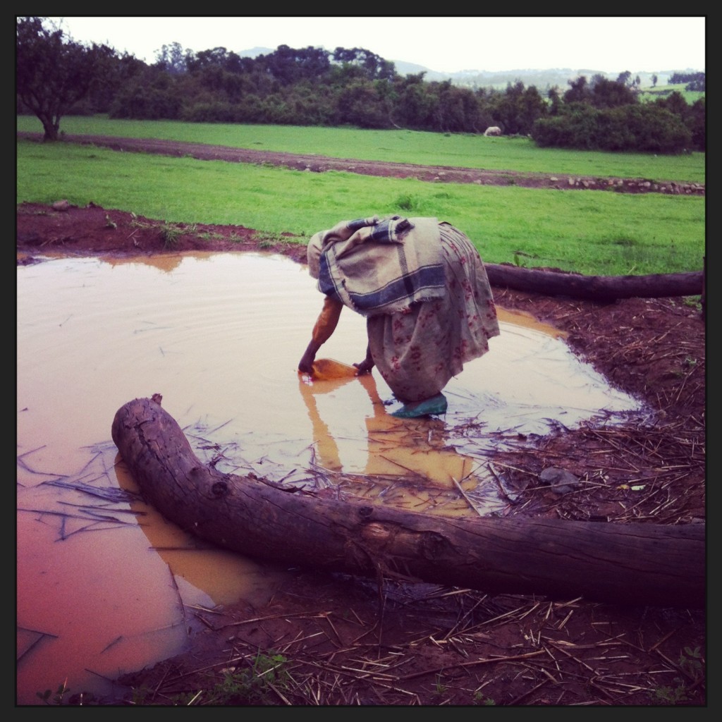 A girl collecting water from a polluted pond in Ethiopia 